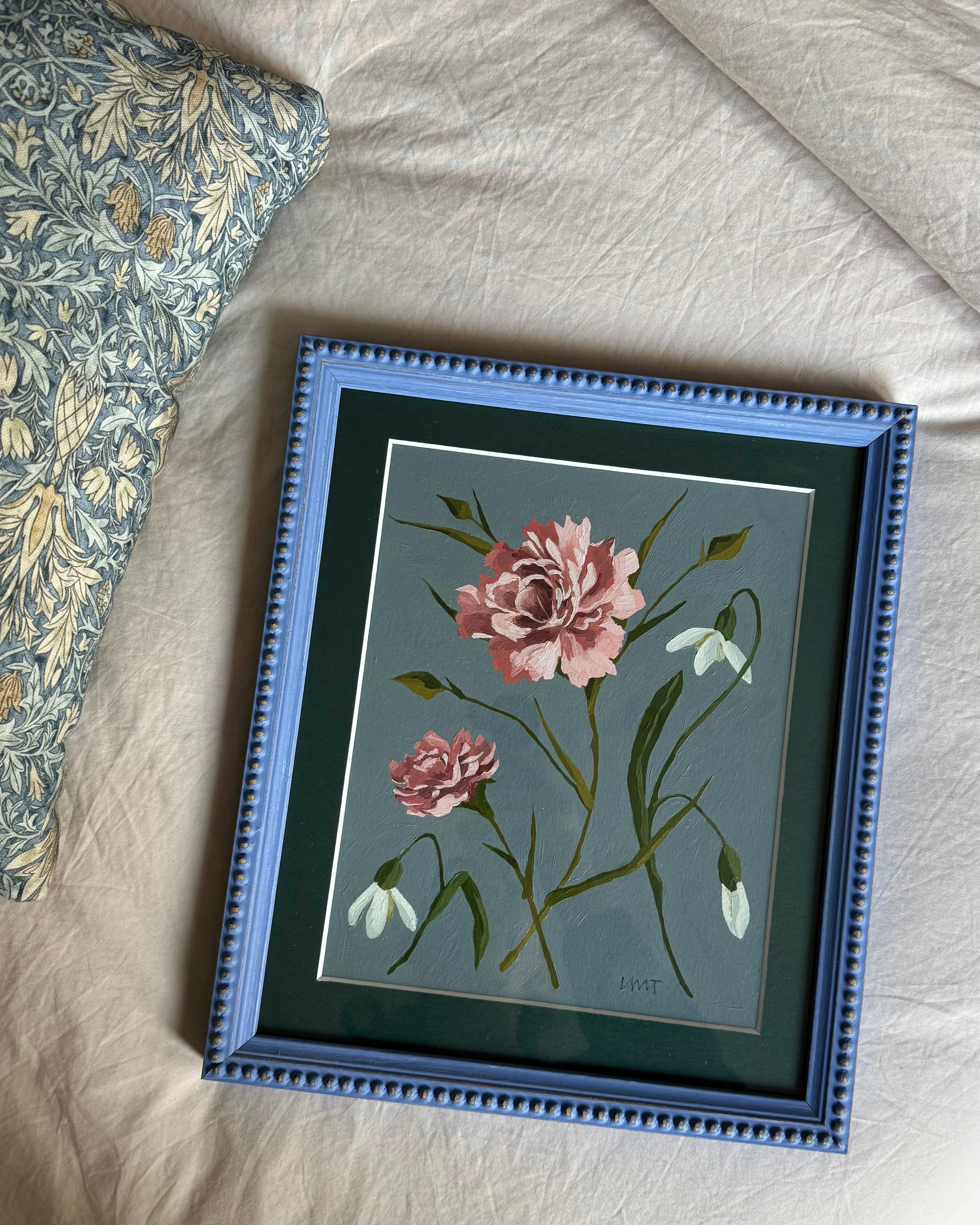 Framed artwork of pink flowers on a textured surface